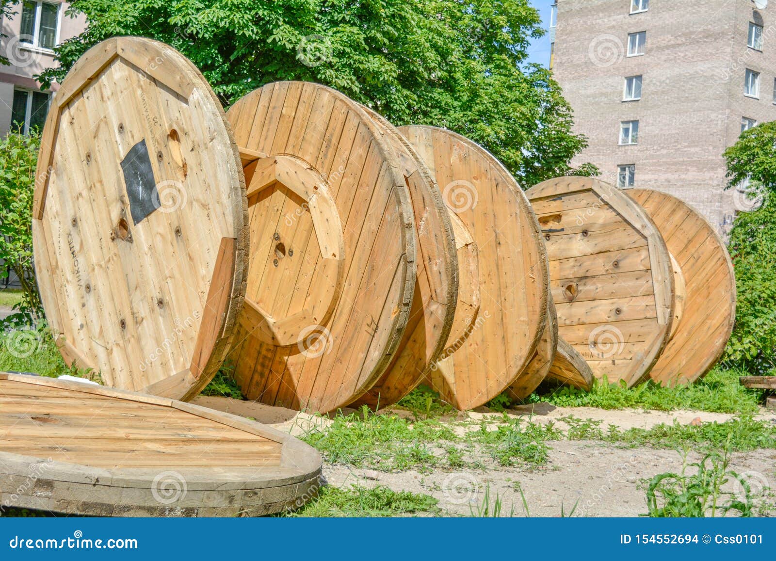 Large Empty Spools and Reels of Wooden Cable Drums Stacked Outdoor Near