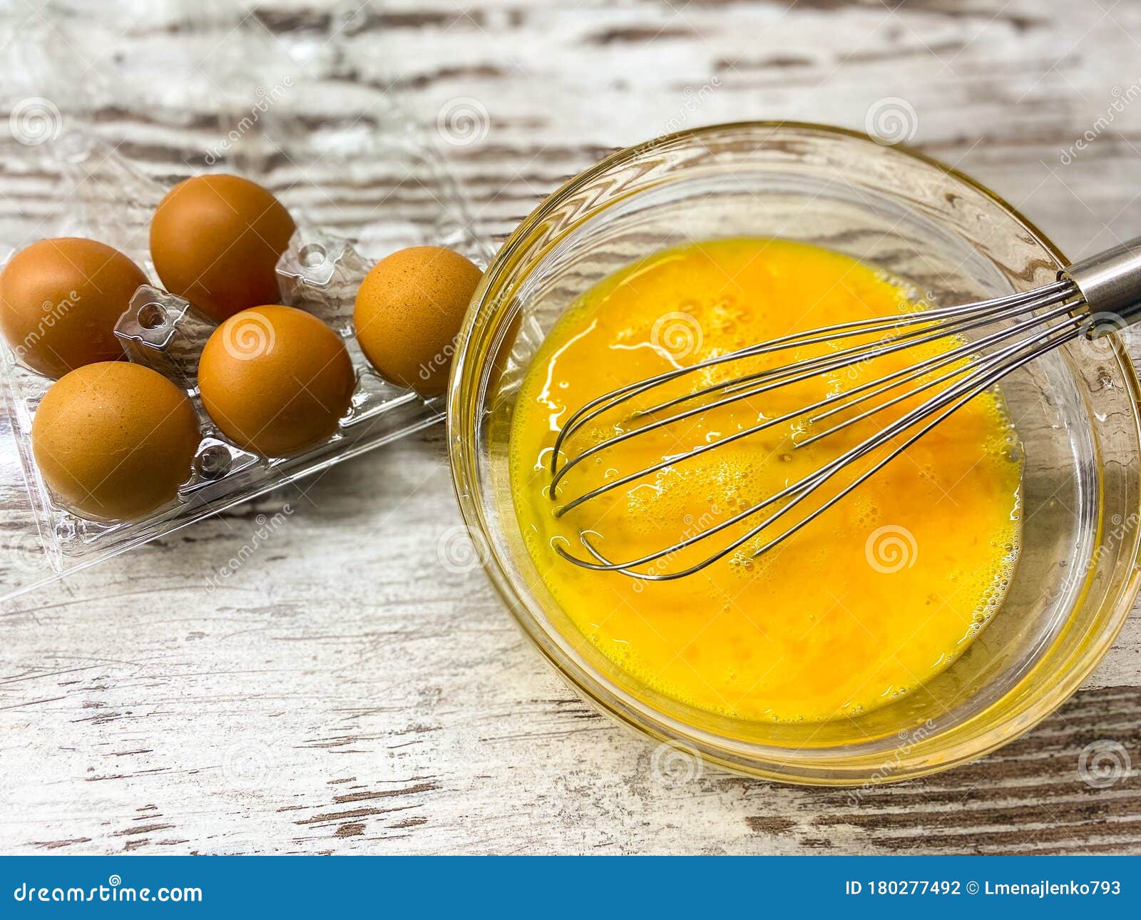 A Large Glass Bowl with a Process of Beating Eggs for Cooking. Stock