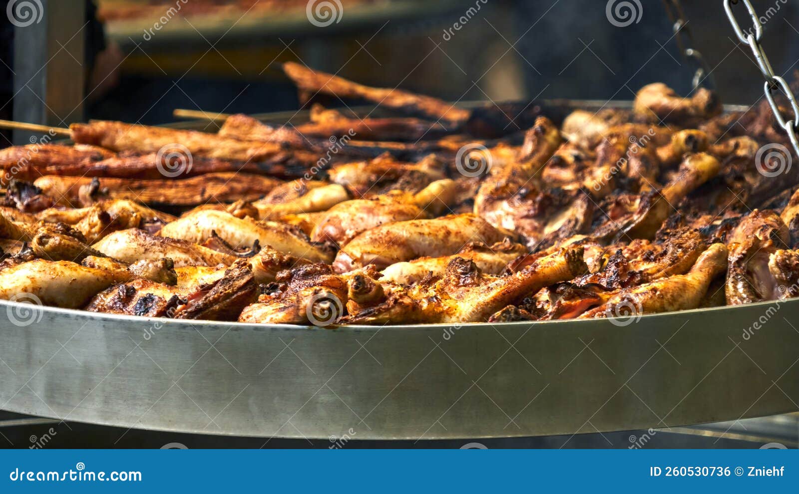 Large Grill with Brown Chicken Thighs on a Turntable, Sharpness in the