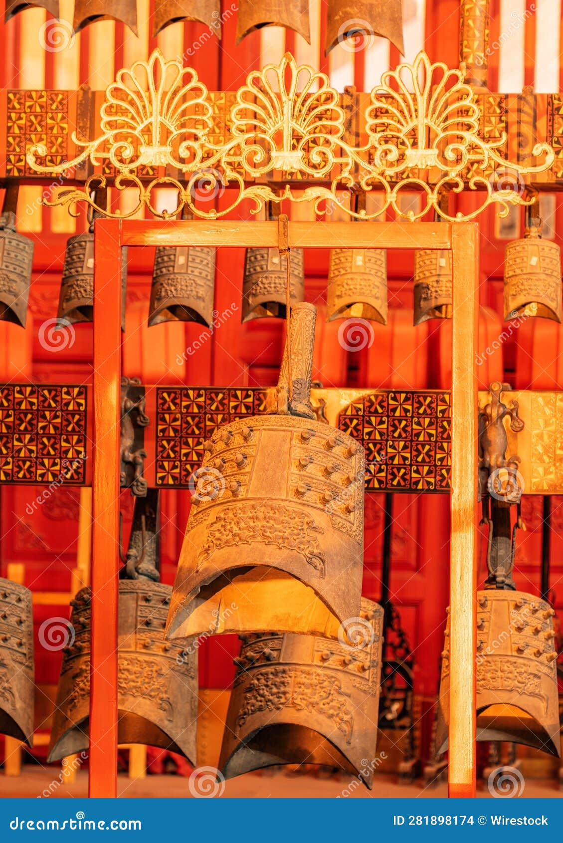 A Large Group of Bells Hanging from a Metal Rack with Other Bells