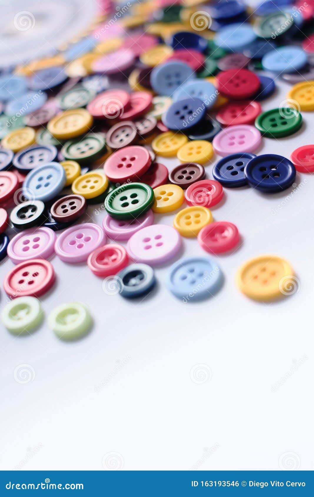 Large Group of Colorful Plastic Sewing Buttons on Table Stock Photo