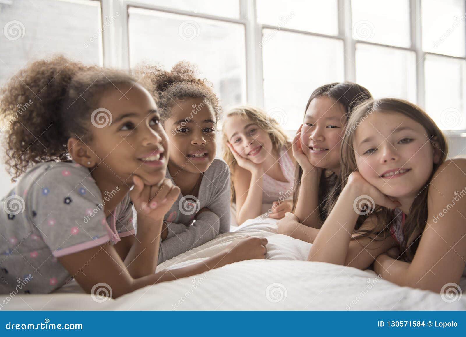 Large Group of Her Friends Taking Goog Time on Bed Stock Photo Image