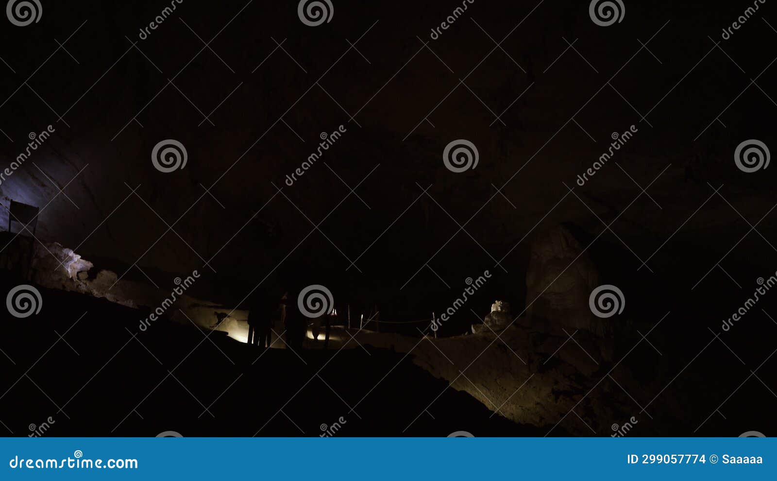 Group of People Exploring Dark Cave with Flashlights Guided Tour