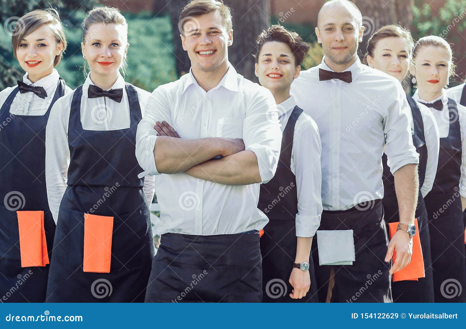 Large Group of Waiters and Waitresses Who Stand in the Row Behin Stock