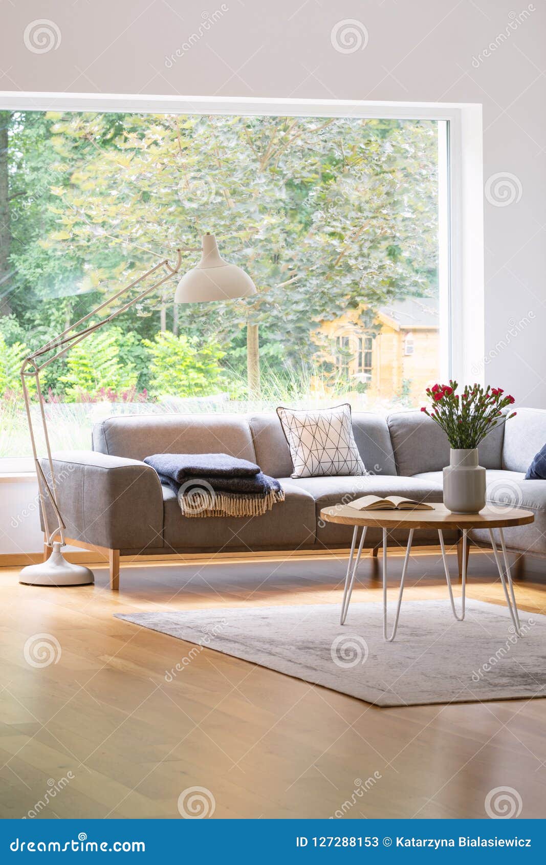 Large Industrial Style Floor Lamp Above An Elegant Sofa In A