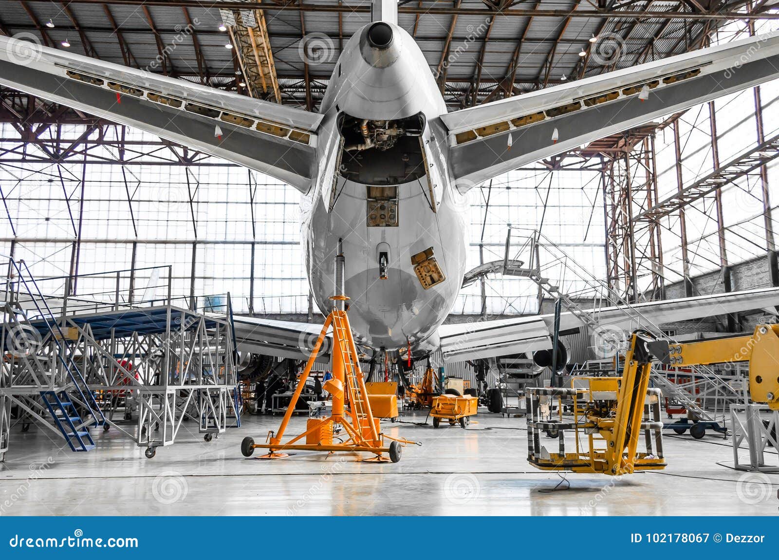 large passenger aircraft on service in an aviation hangar rear view of the tail, on the auxiliary power unit.