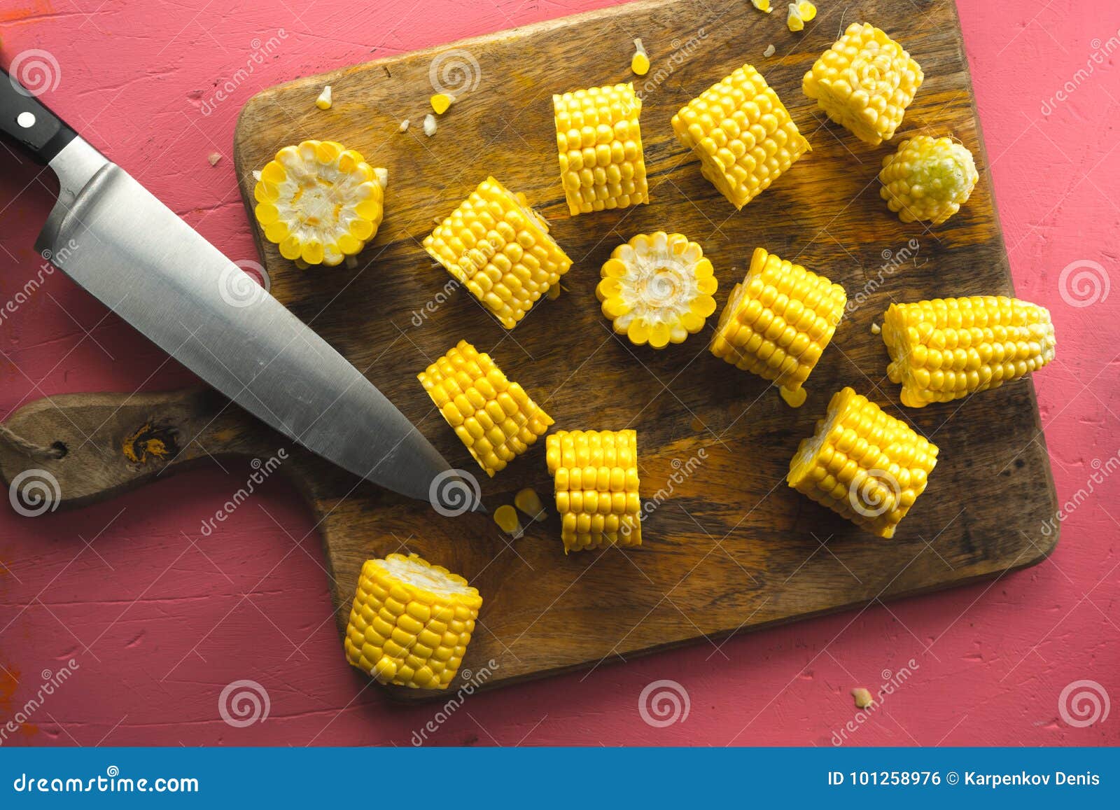 Large Pieces of Corn on a Cutting Board and Kitchen Knife Stock Photo