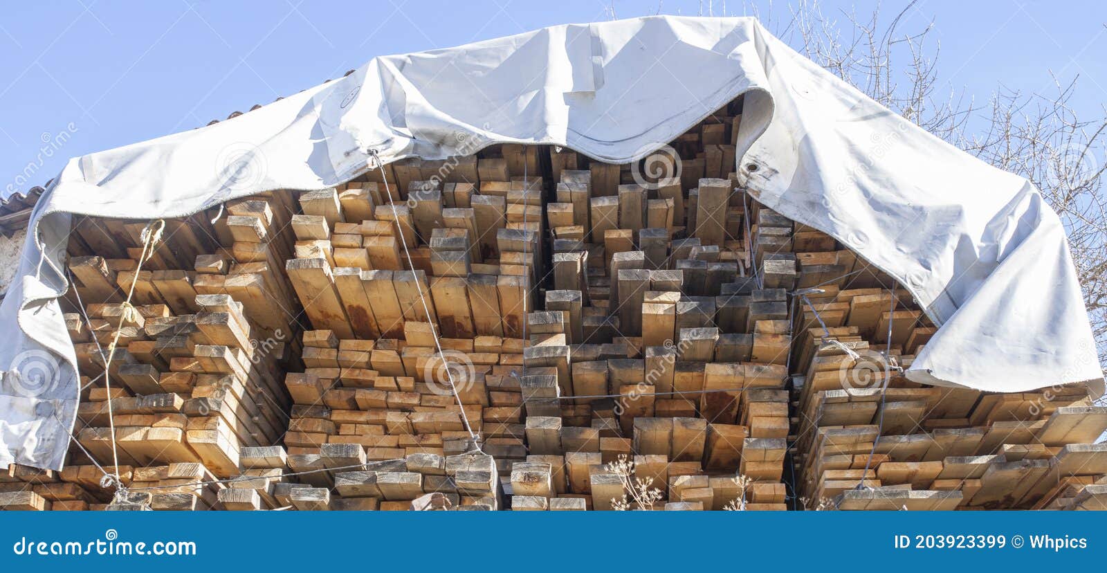 Large Pile Stack of Timber Protected by Waterproof Canvas Tarps Stock