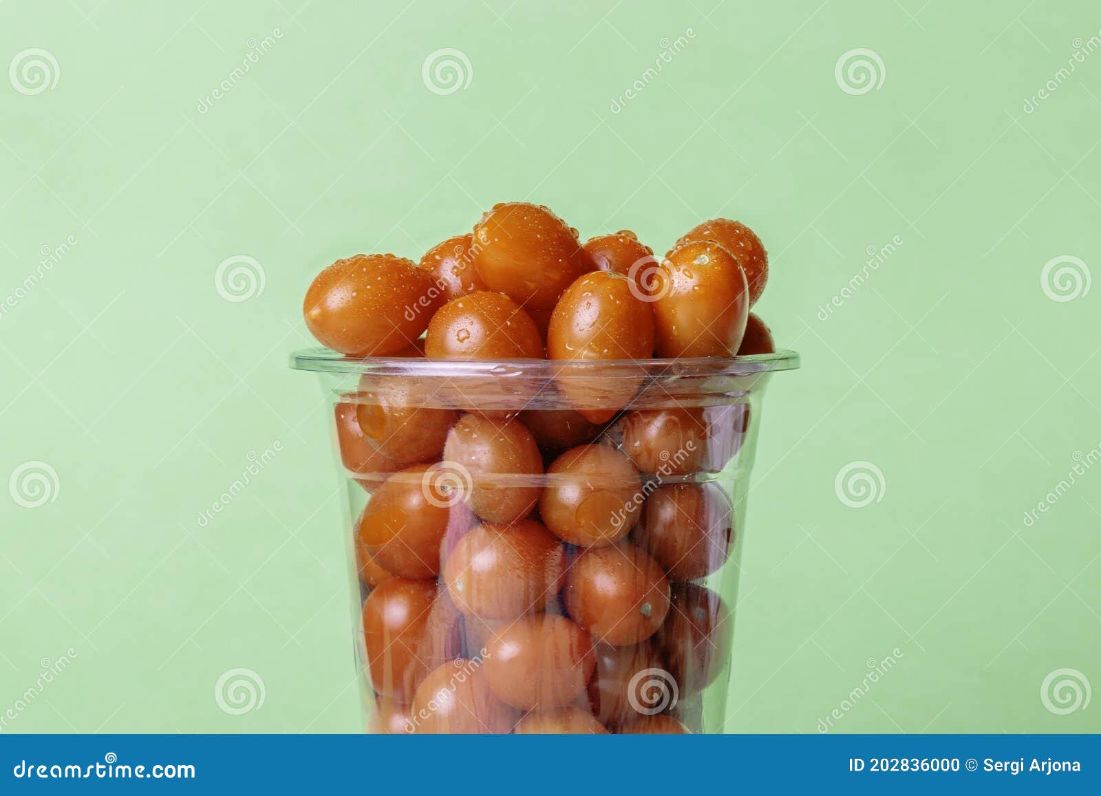 Large Plastic Cup Filled To the Brim with Cherry Tomatoes Stock Photo