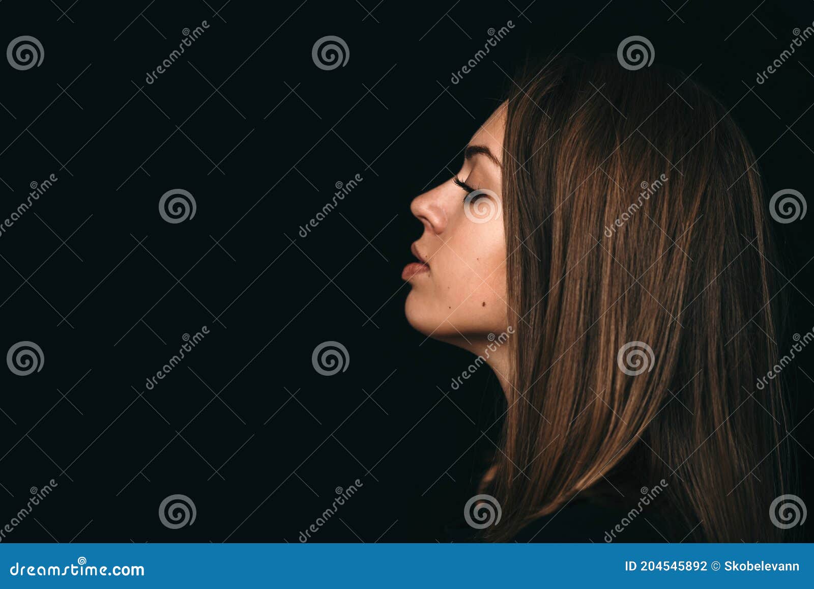Large Portrait of the Girl`s Profile. Girl`s Face on a Black