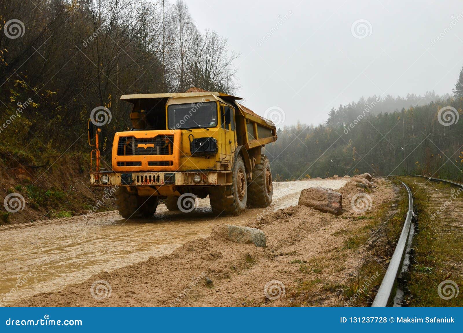 large quarry dump truck. view of the large sand pit. production useful minerals. loading the rock.
