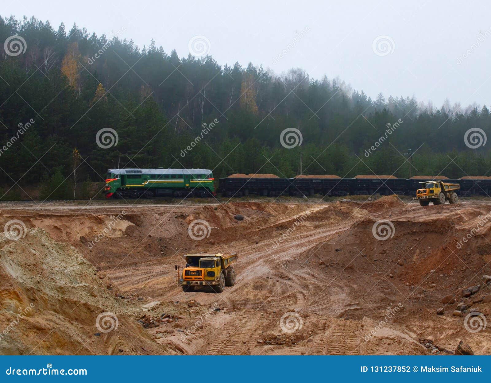 large quarry dump truck. view of the large sand pit. production useful minerals. loading the rock.