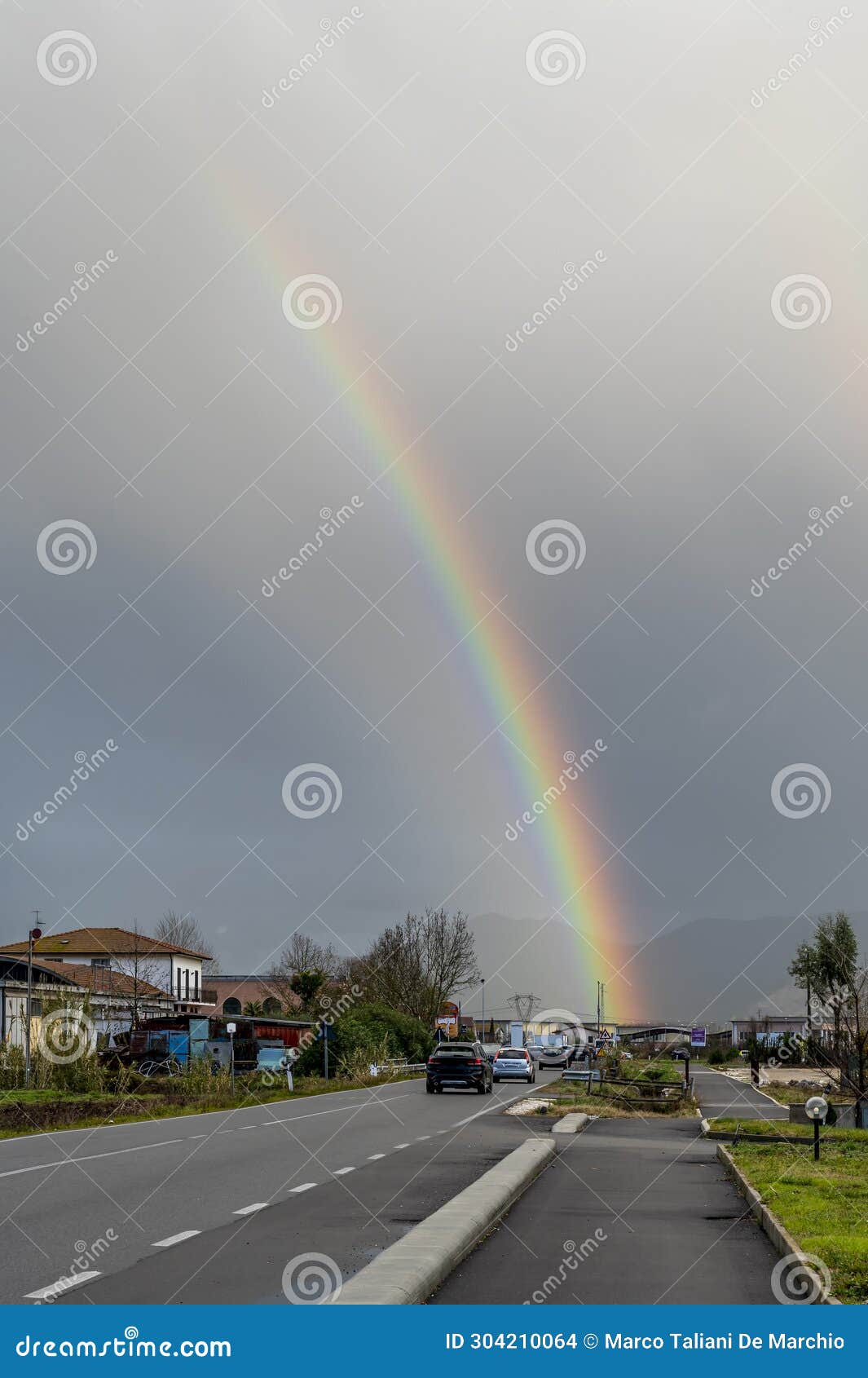 a large rainbow on the road that crosses the hamlet of lavoria, crespina lorenzana, pisa, italy