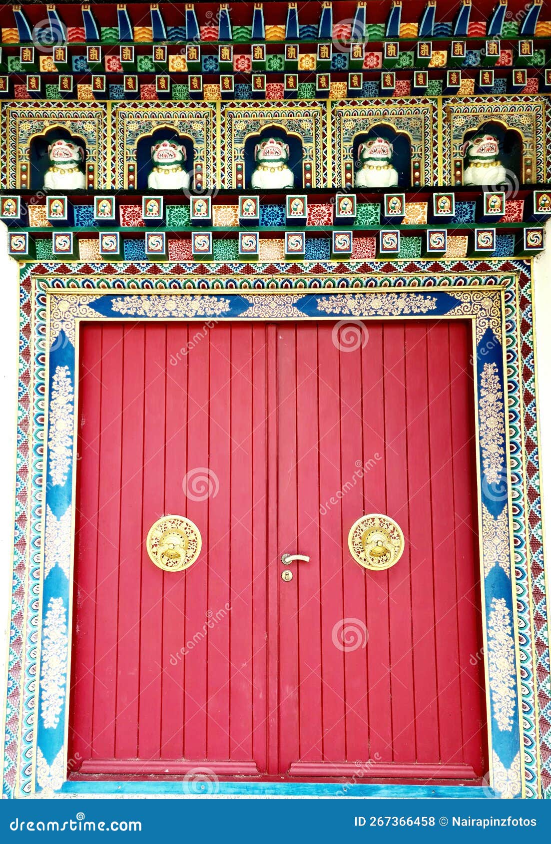 large red door with gold handles statues of temple guardian dogs