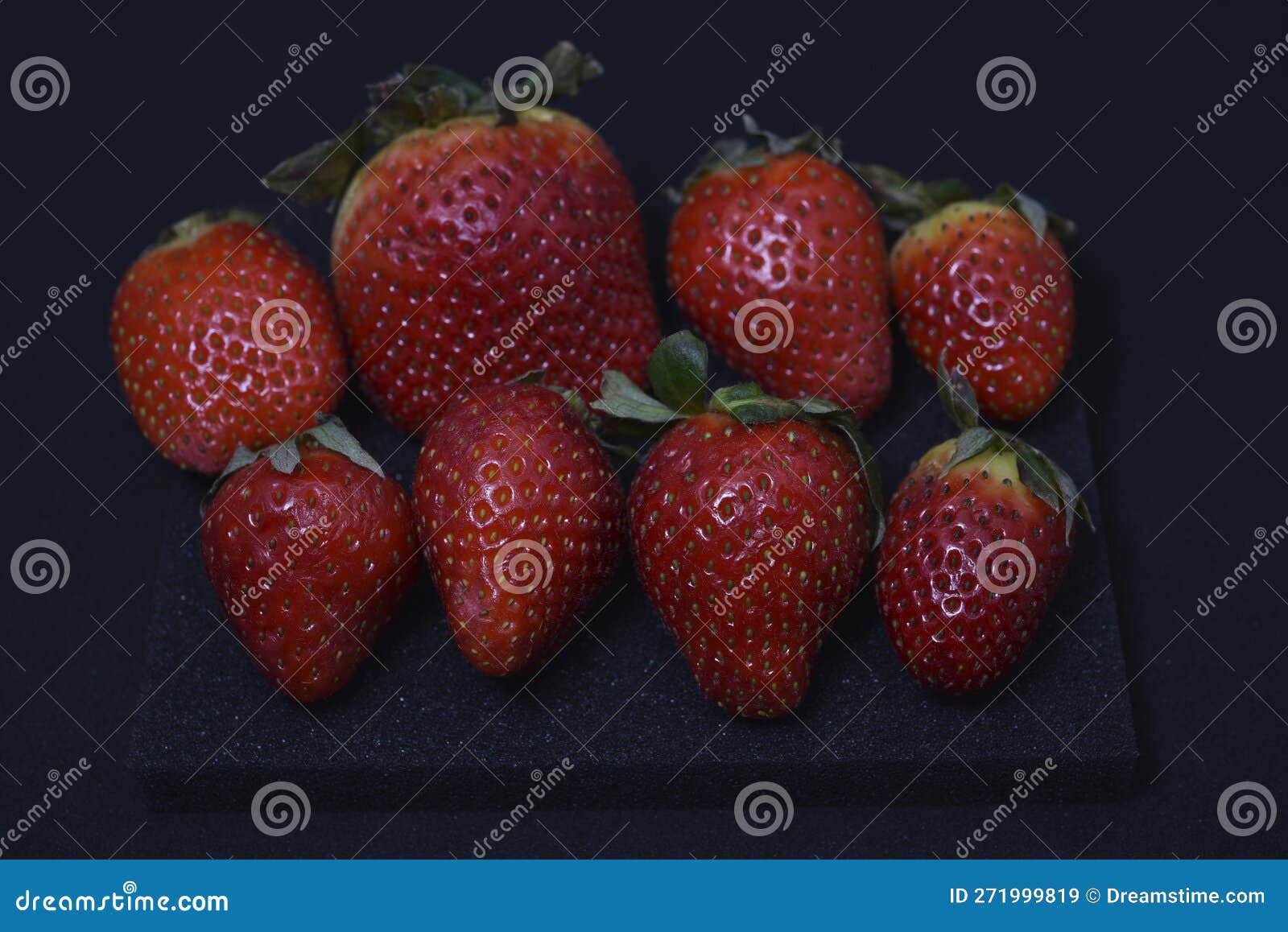 Large Red Strawberries on a Black Plastic Litter. Red Strawberries