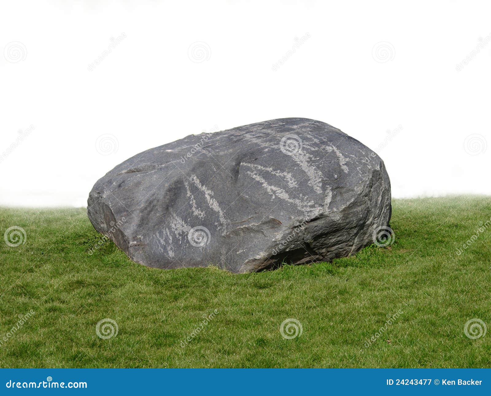 large rock boulder on grass .