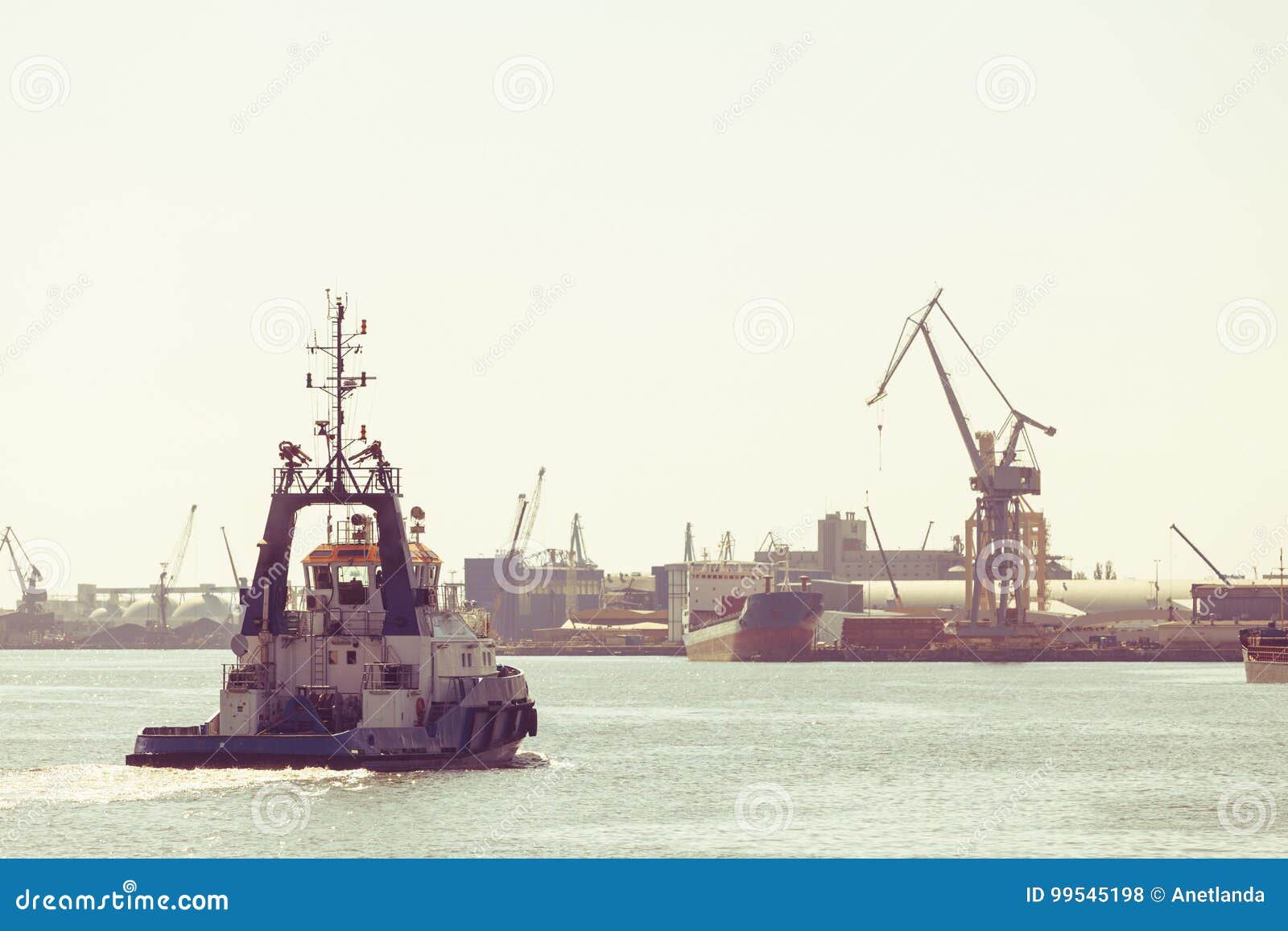 Large ship arriving in port. Large ship arriving to Gdynia port. Tugboat in sunny day. Transport concept.