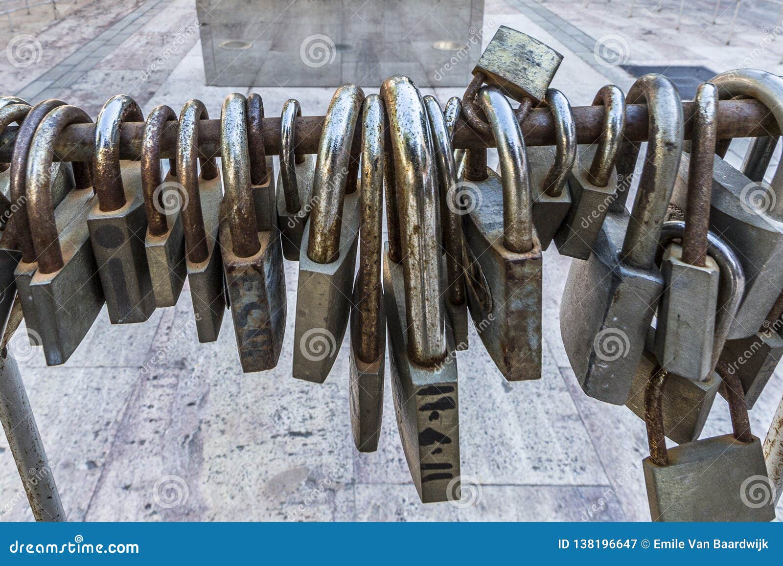large and small rusty padlocks on a metal railing