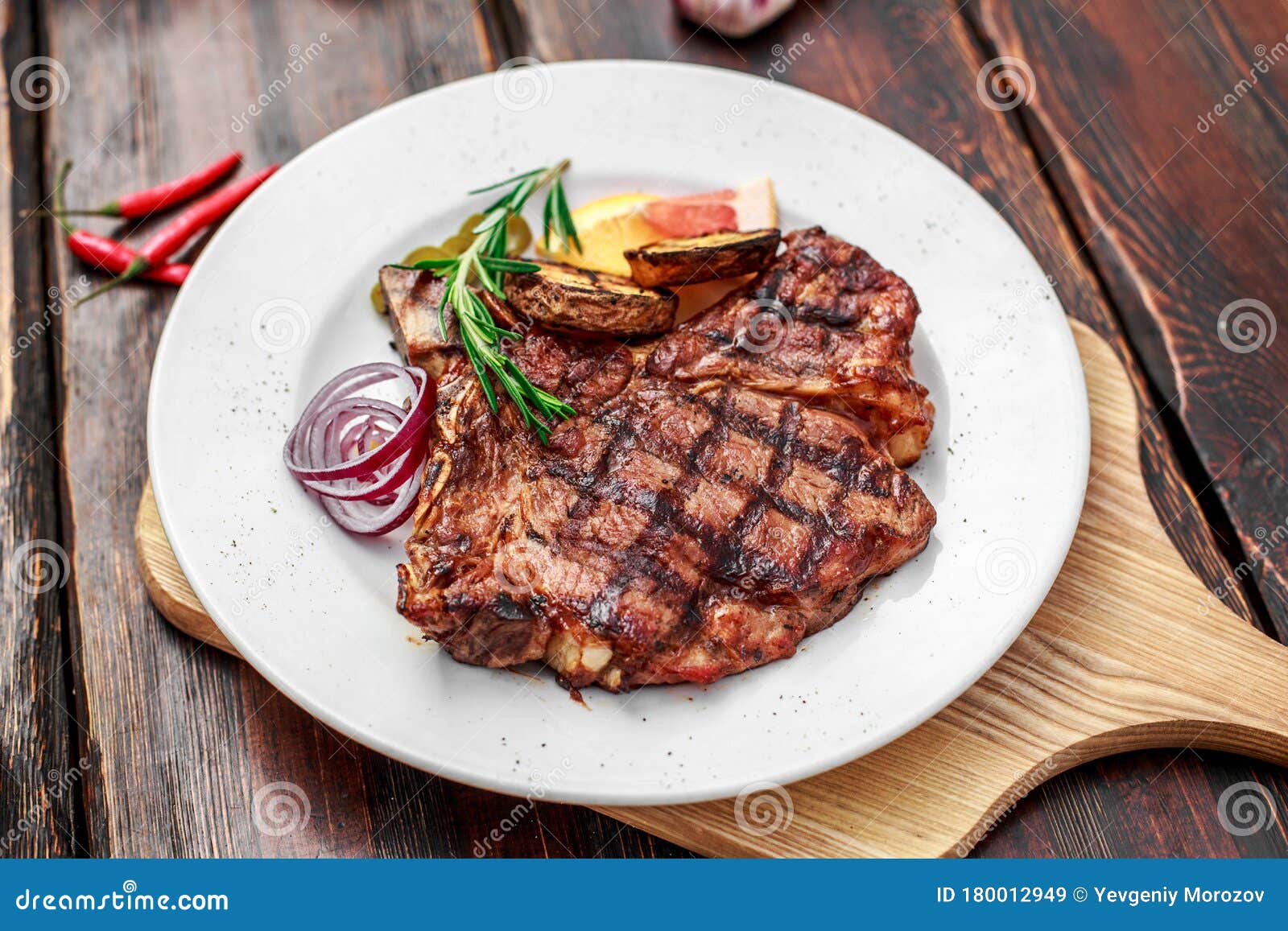A Large Steak with Spices and Vegetables on the Grill Stock Image