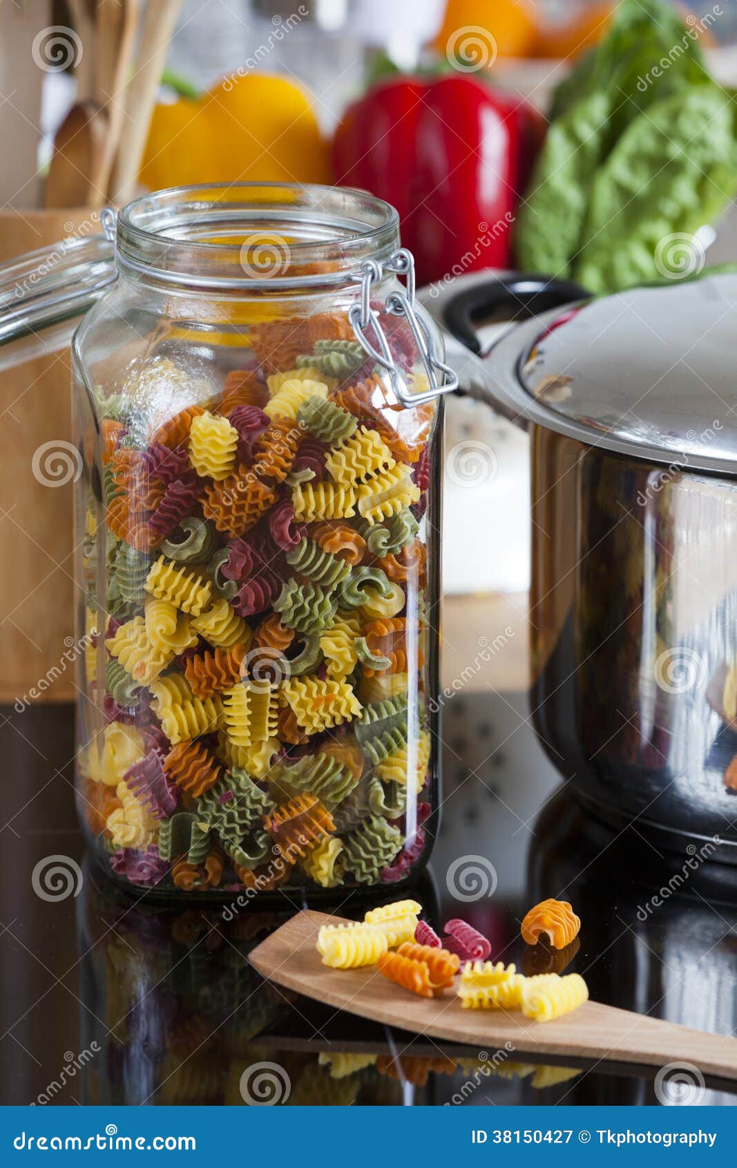 Large Storage Jar with Colorful Pasta and Cooking Spoon Stock Image
