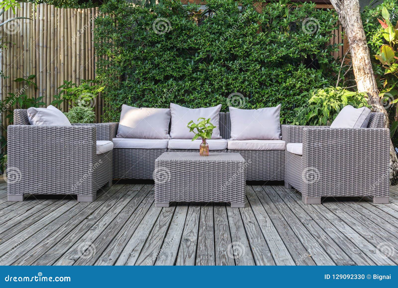 large terrace patio with rattan garden furniture in the garden on wooden floor.