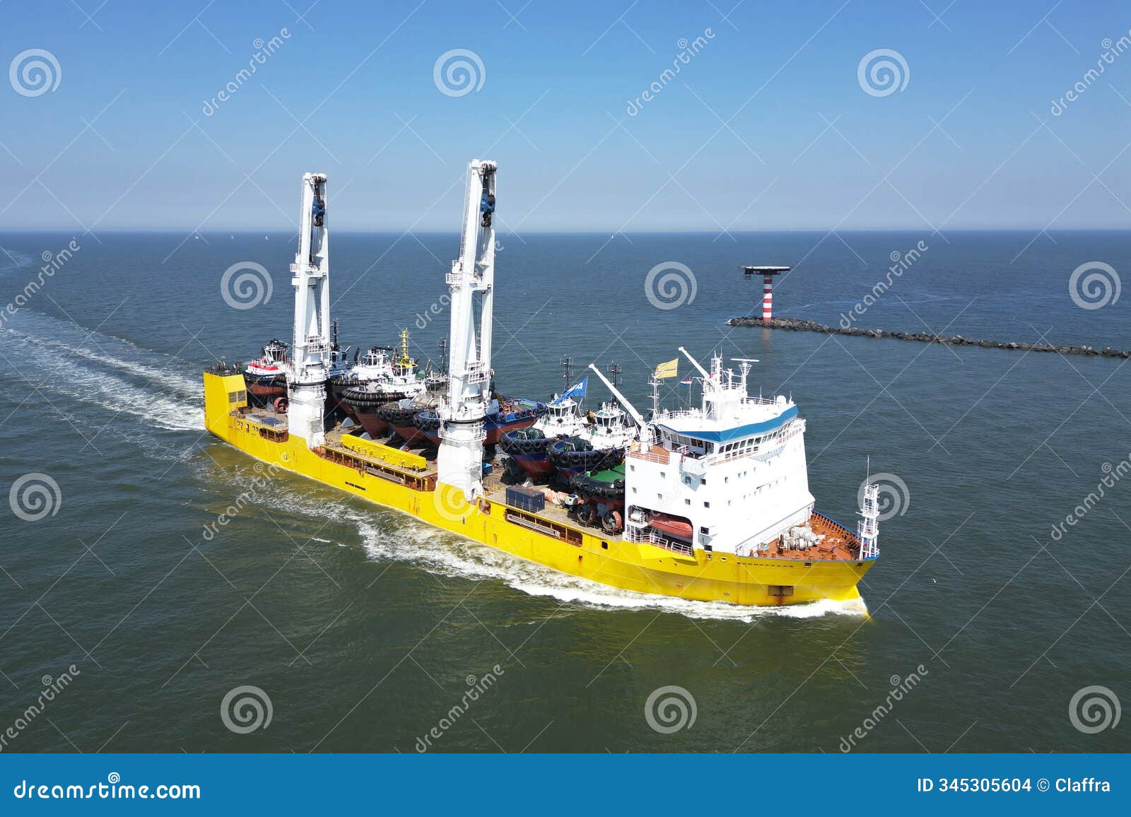 a large vessel with unique lifting capabilities carrying multiple tugboats