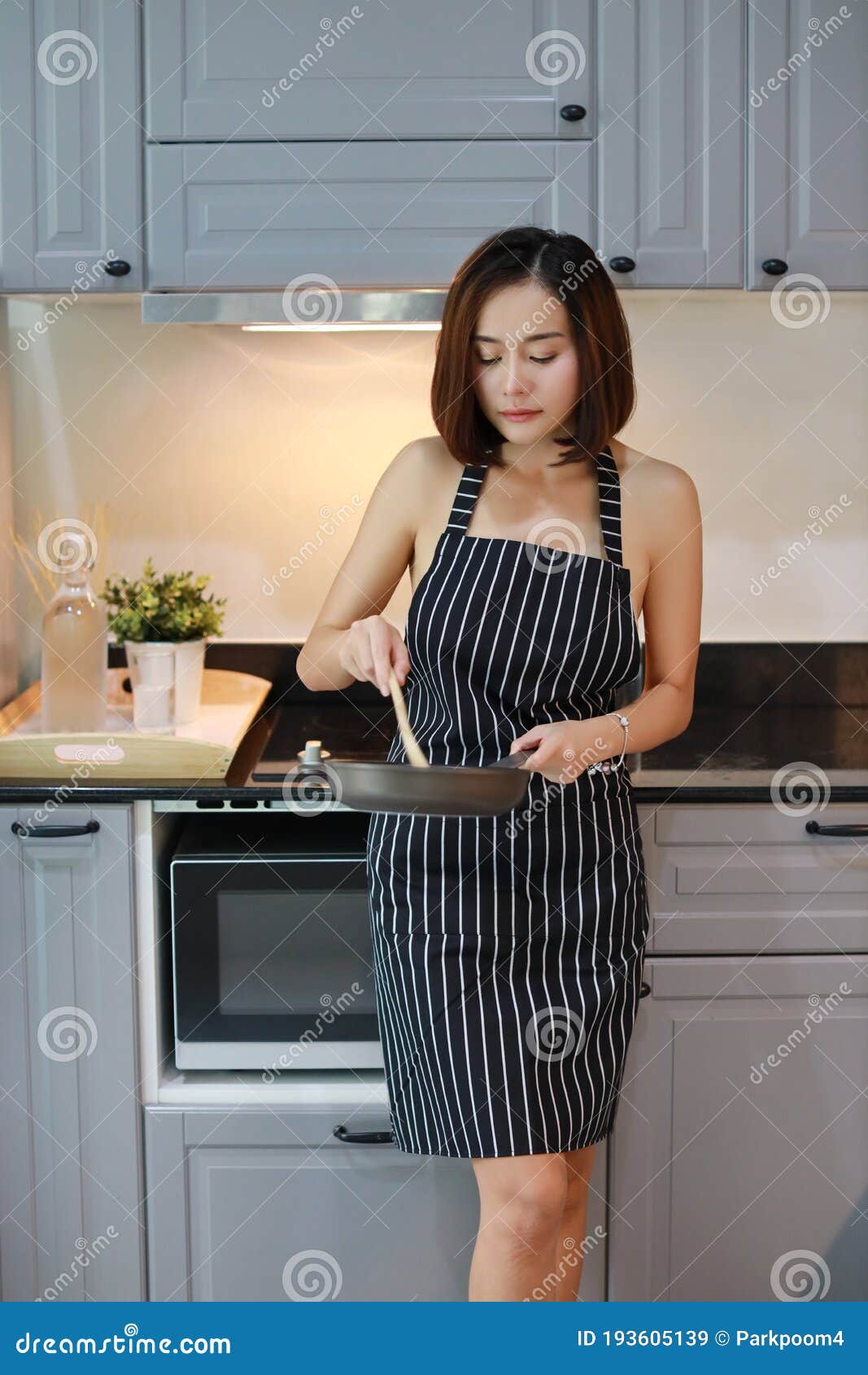 Largo De La Sexy Y Atractiva Chica Asiática Con Vestido Sexy Blanco Y Negro Cocinando En La Cocina Con Cara Sonriente De Vacacione Imagen de archivo