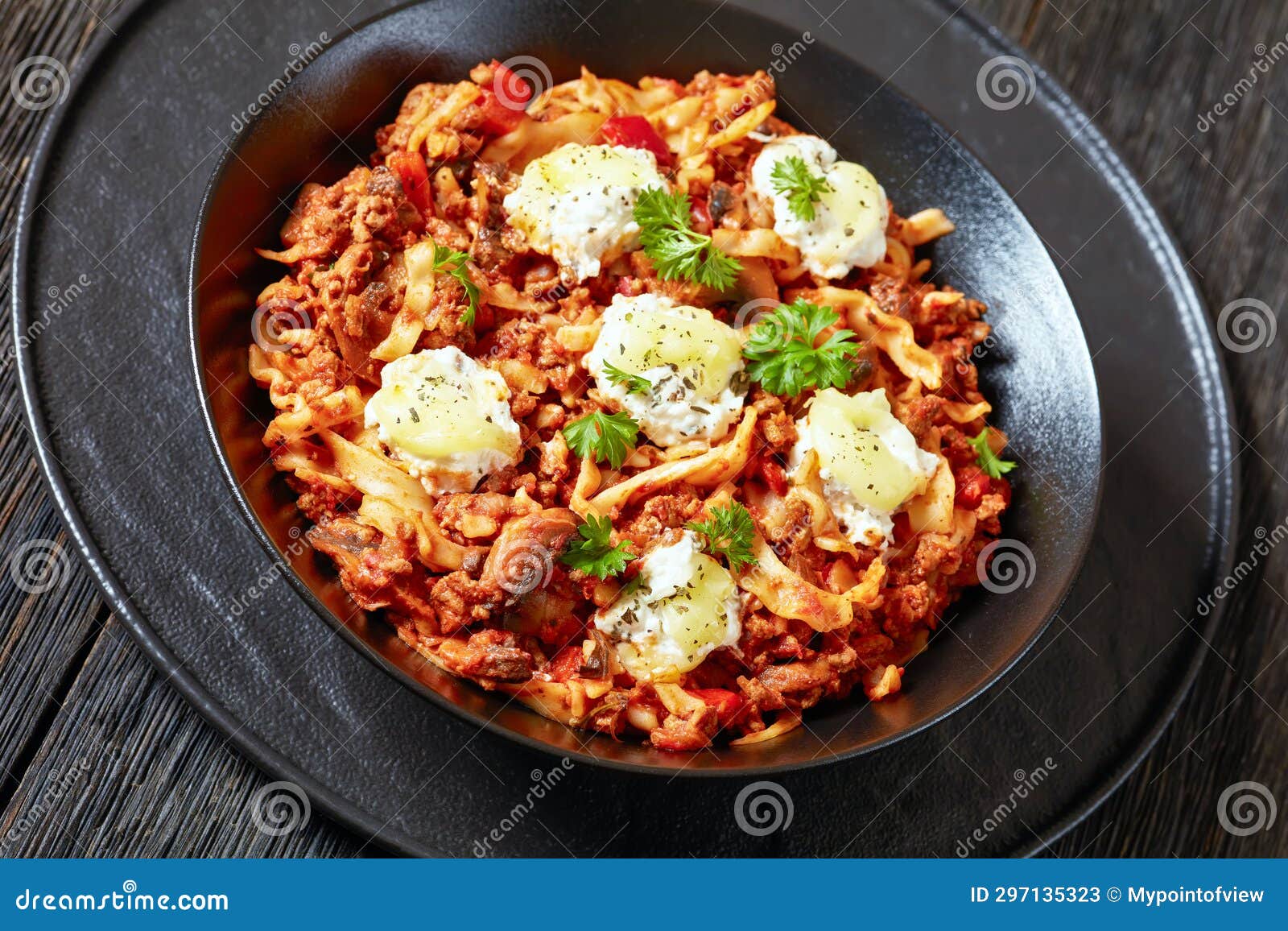 lasagnette with beef ragu, mushrooms and ricotta cheese in black bowl