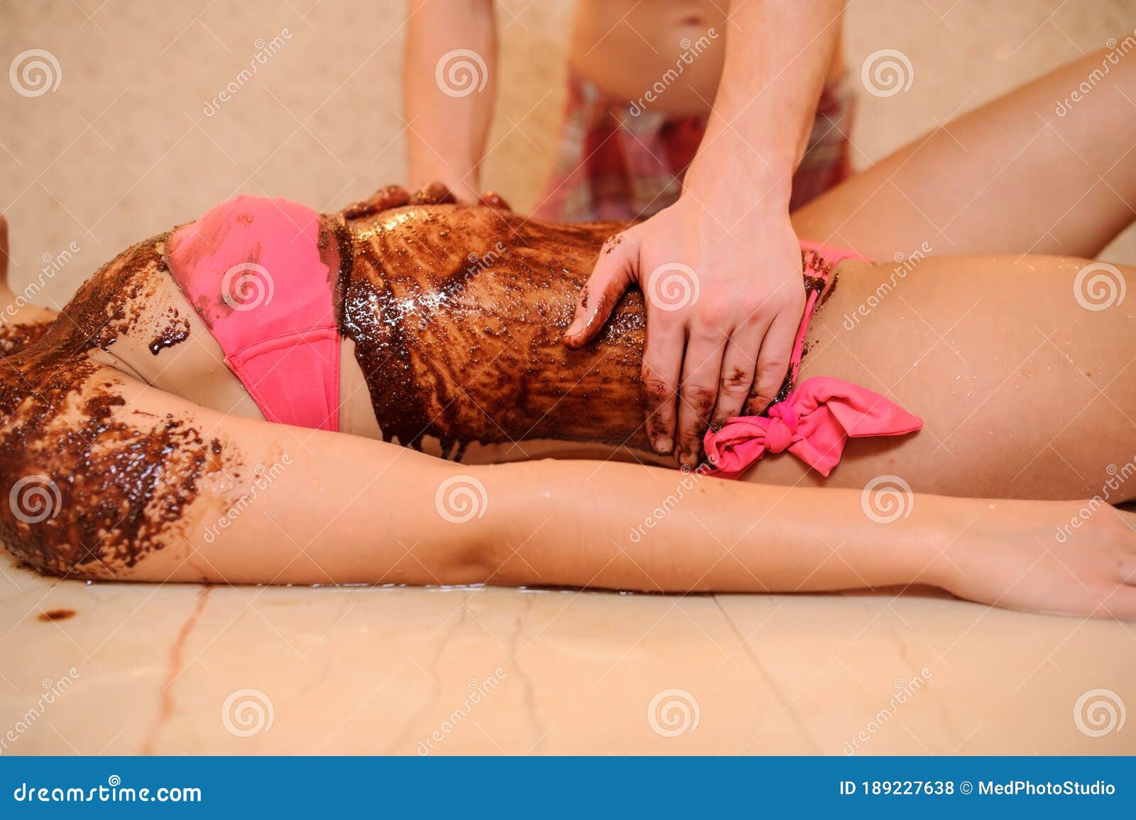 Young Woman Having A Chocolate Massage On Her Abdomen Done