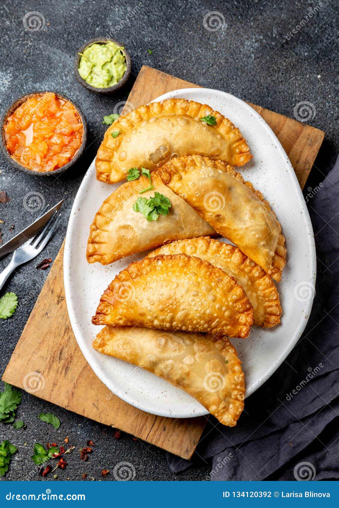 latin american fried empanadas with tomato and avocado sauces. top view
