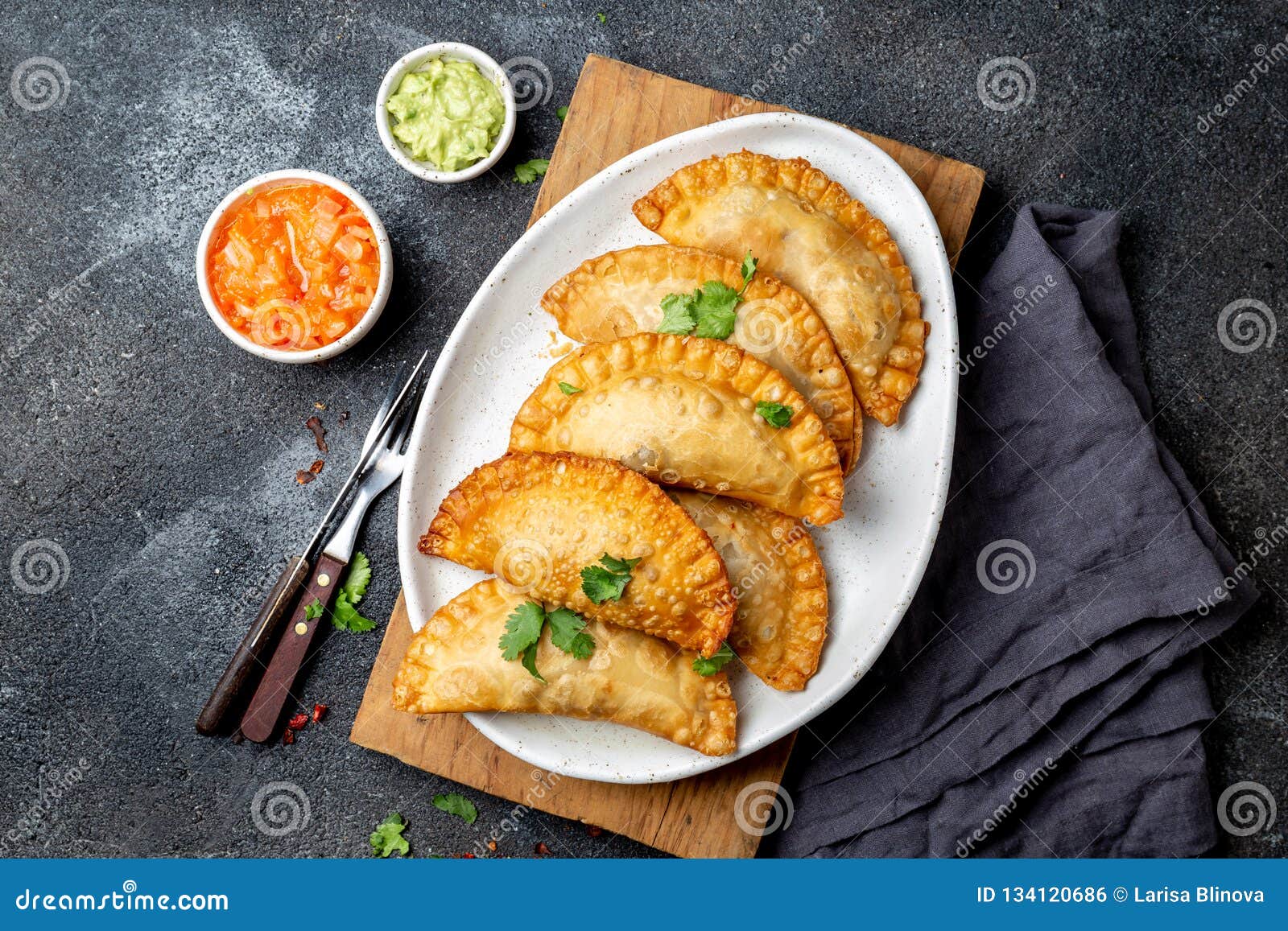 latin american fried empanadas with tomato and avocado sauces. top view