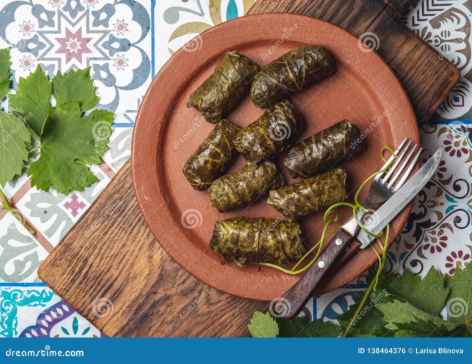 latin american mexican chilean cuisine. ninos envueltos. grape leaves stuffed wish meat on clay plate