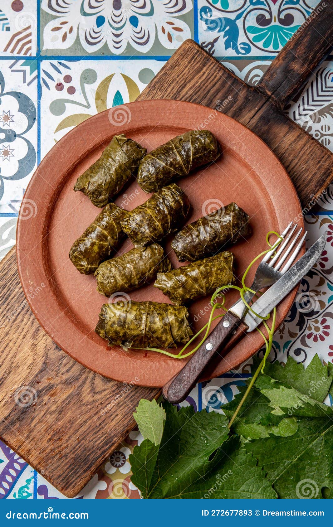 latin american mexican chilean cuisine. ninos envueltos. grape leaves stuffed wish meat on clay plate