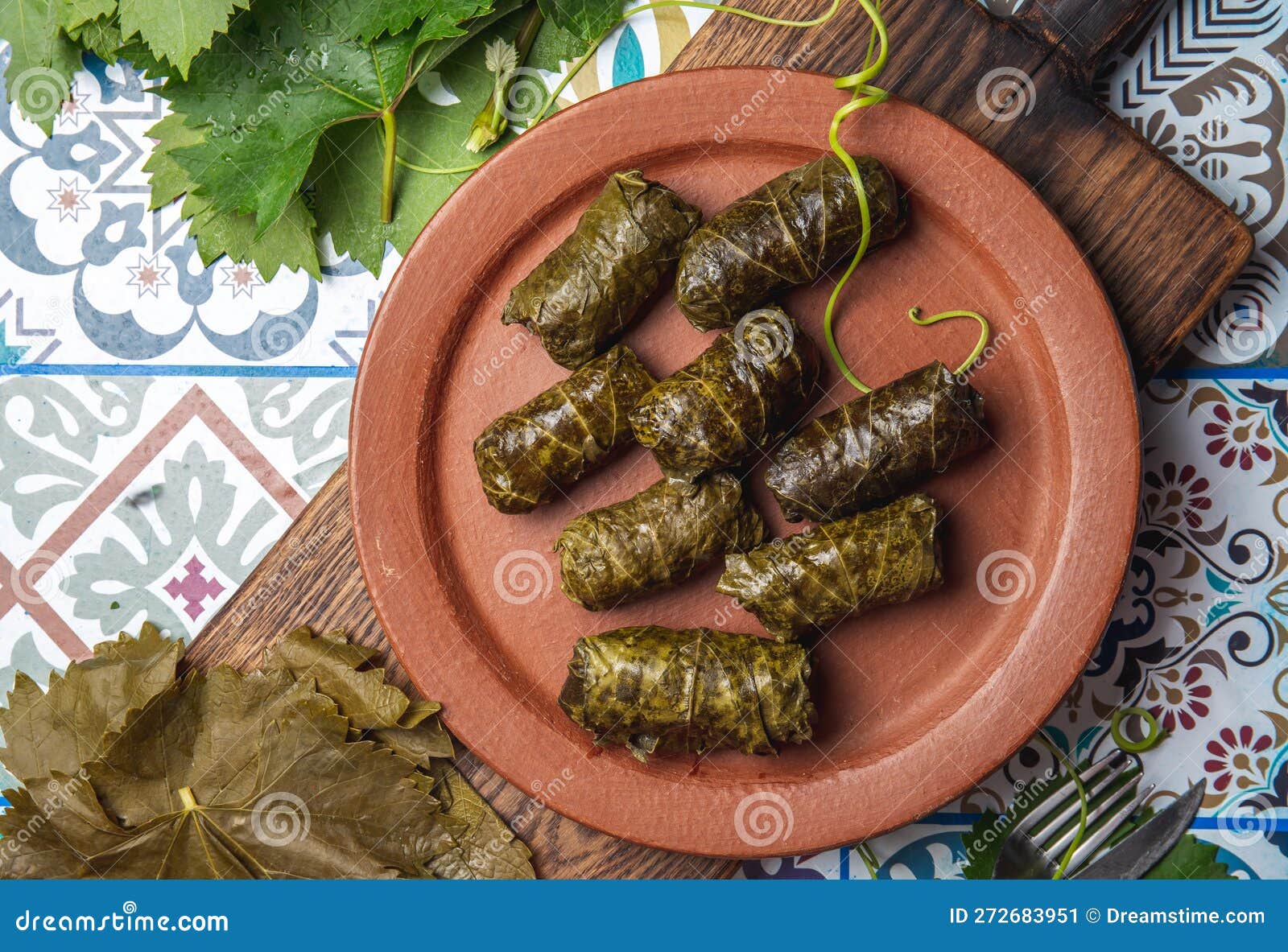 latin american mexican chilean cuisine. ninos envueltos. grape leaves stuffed wish meat on clay plate