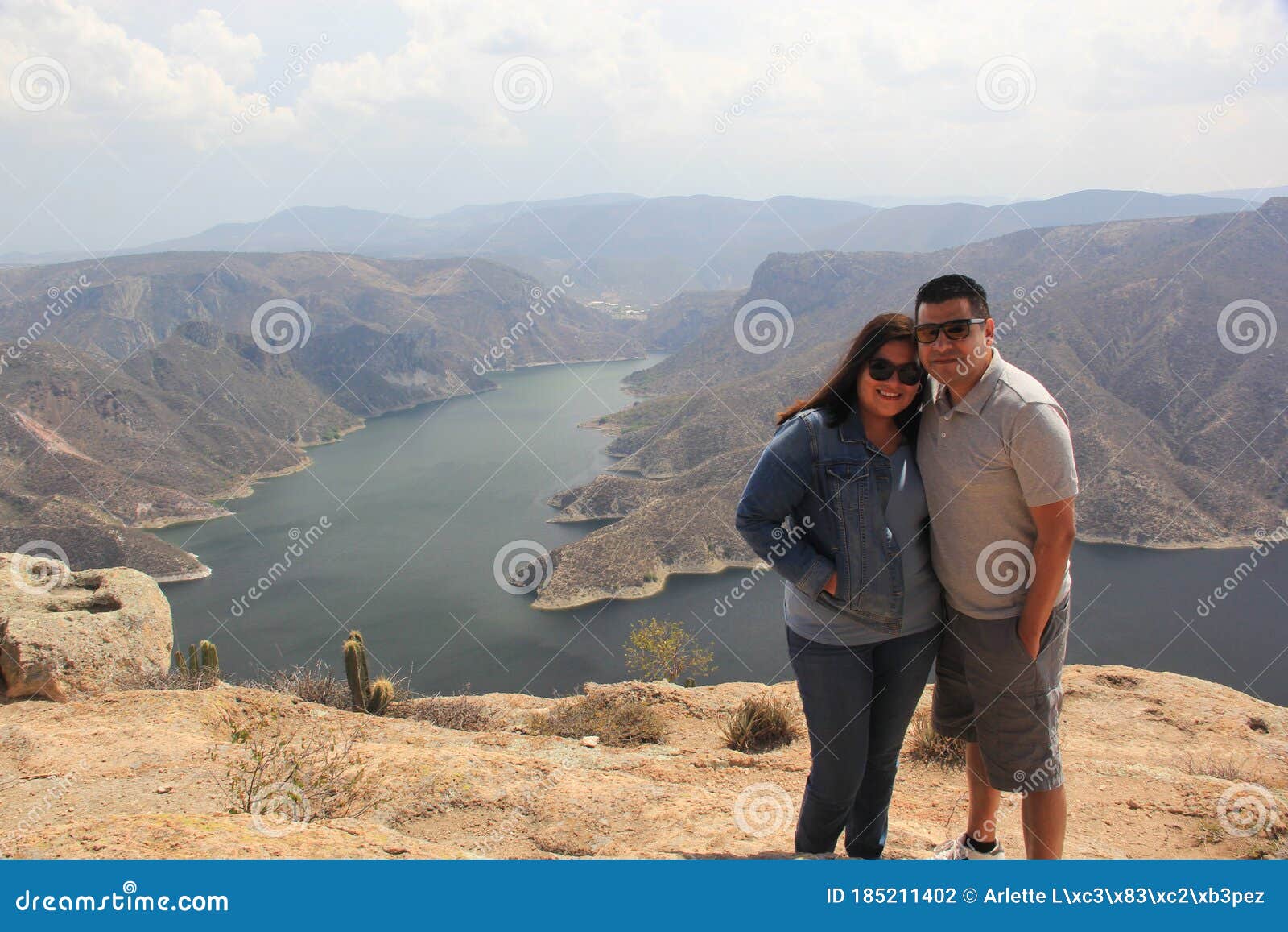 latin couple with sunglasses in the viewpoint el vigilante, in the background the zimapan dam in hidalgo mexico