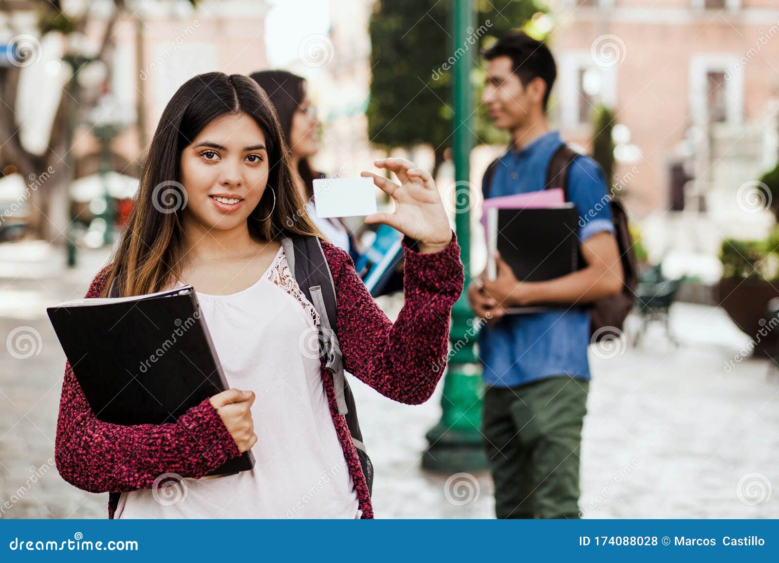 latin female student or international student in internship holding an id card in mexico city