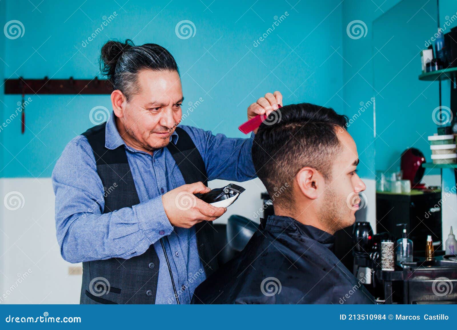 latin man stylist cutting hair to a client in a barber shop in mexico