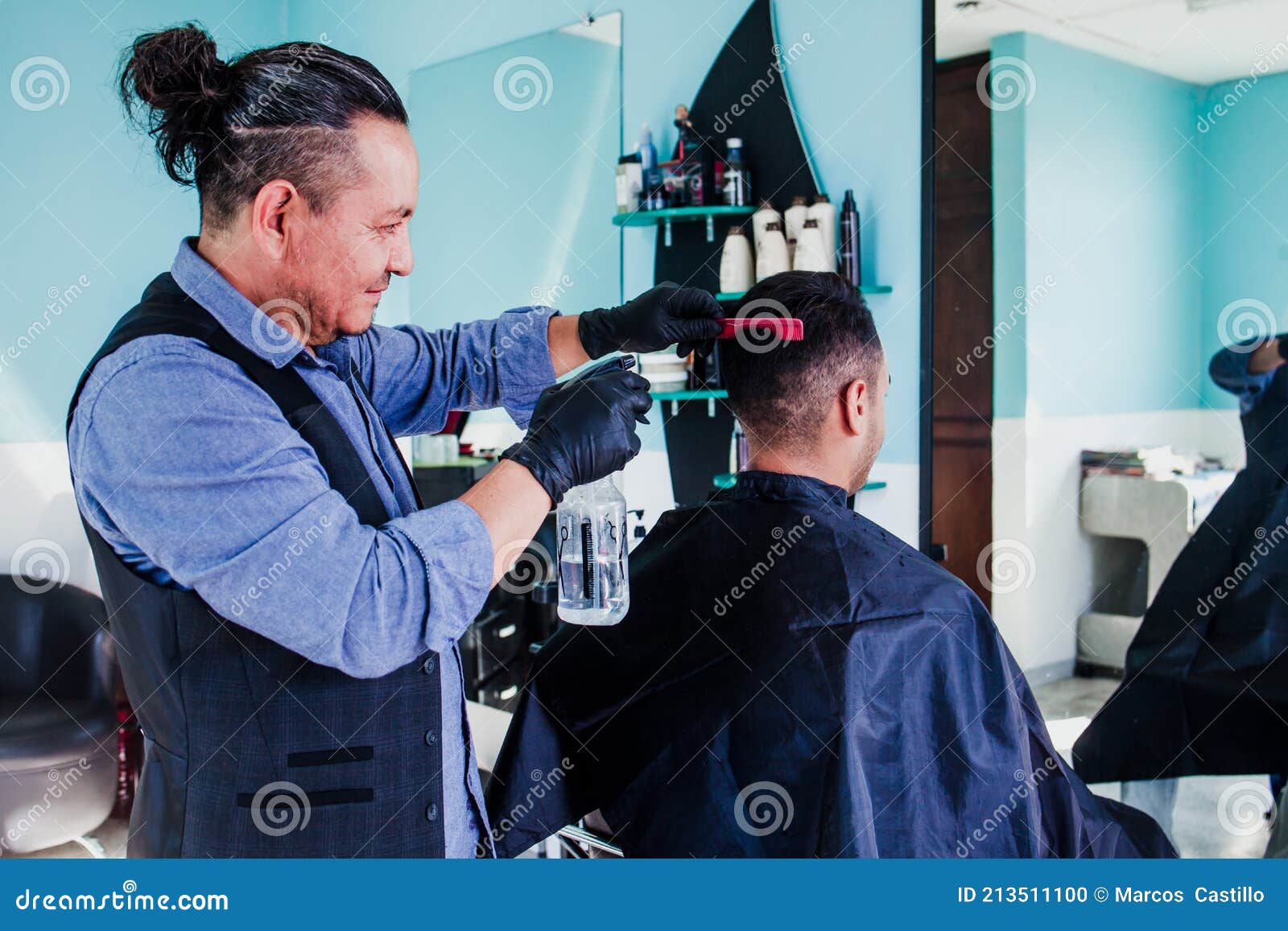latin man stylist cutting hair to a client in a barber shop in mexico