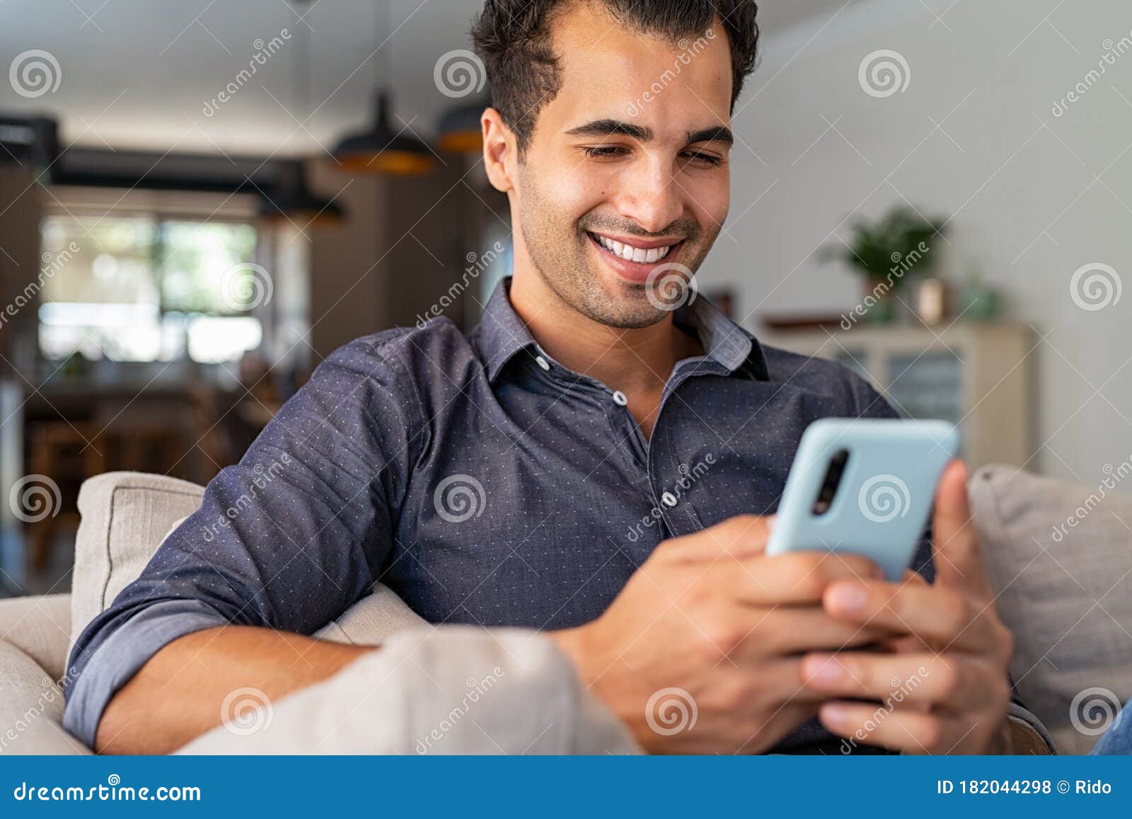 latin man using smartphone at home