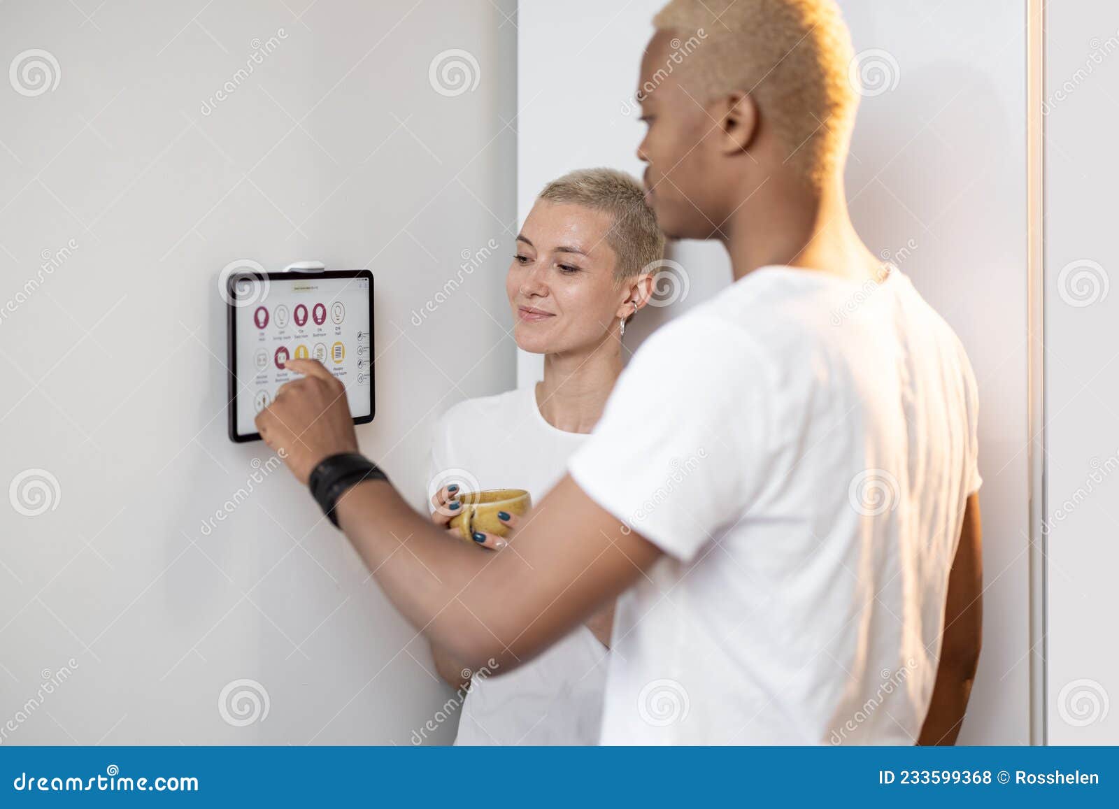 young couple controlling smart home devices on a digital tablet