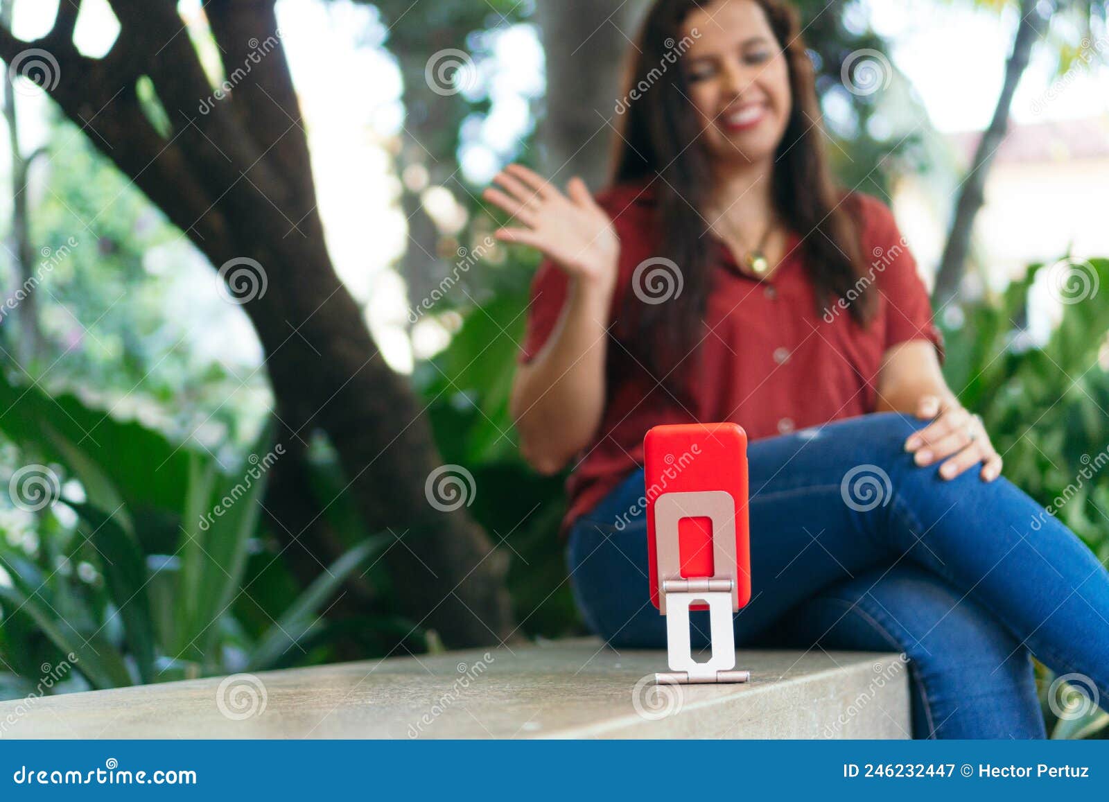 latin woman making a video for her blog with cell phone. concept of vlogging