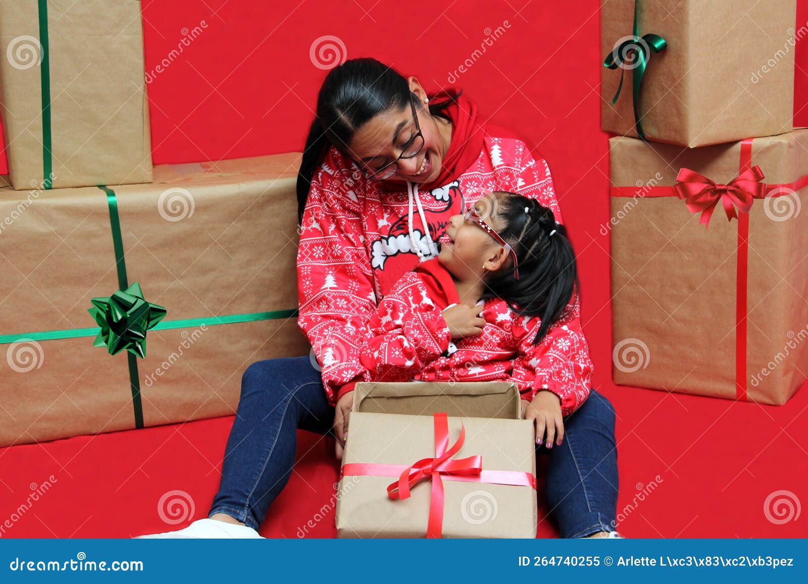 Latina Mom And Daughter With Glasses Wear Ugly Christmas Sweaters And Show Their Love To Each