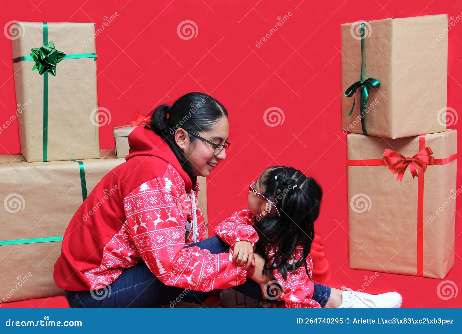 Latina Mom And Daughter With Glasses Wear Ugly Christmas Sweaters And Show Their Love To Each