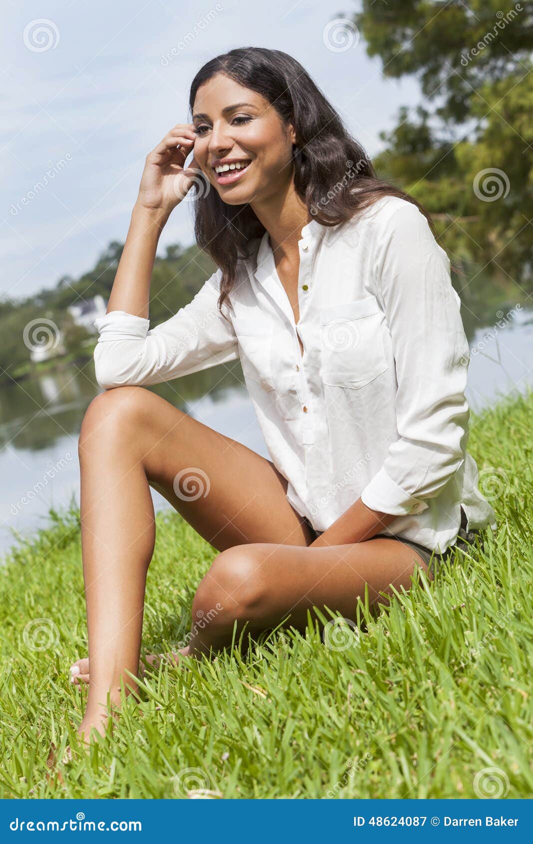 Latina Woman Girl Sitting On Grass By Lake In Summer S