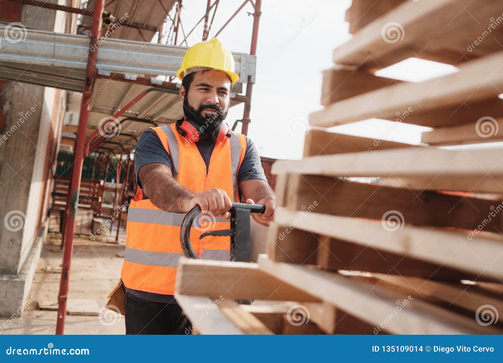 latino manual worker with forkift pallet stacker in construction site