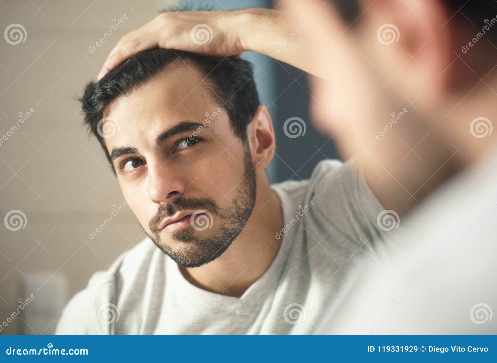 man worried for alopecia checking hair for loss