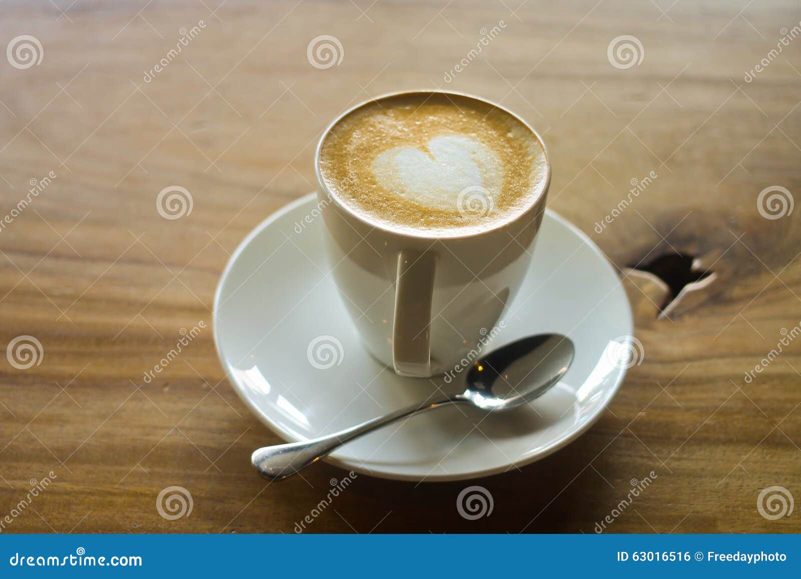 latte art on a cappucinno , on wooden table