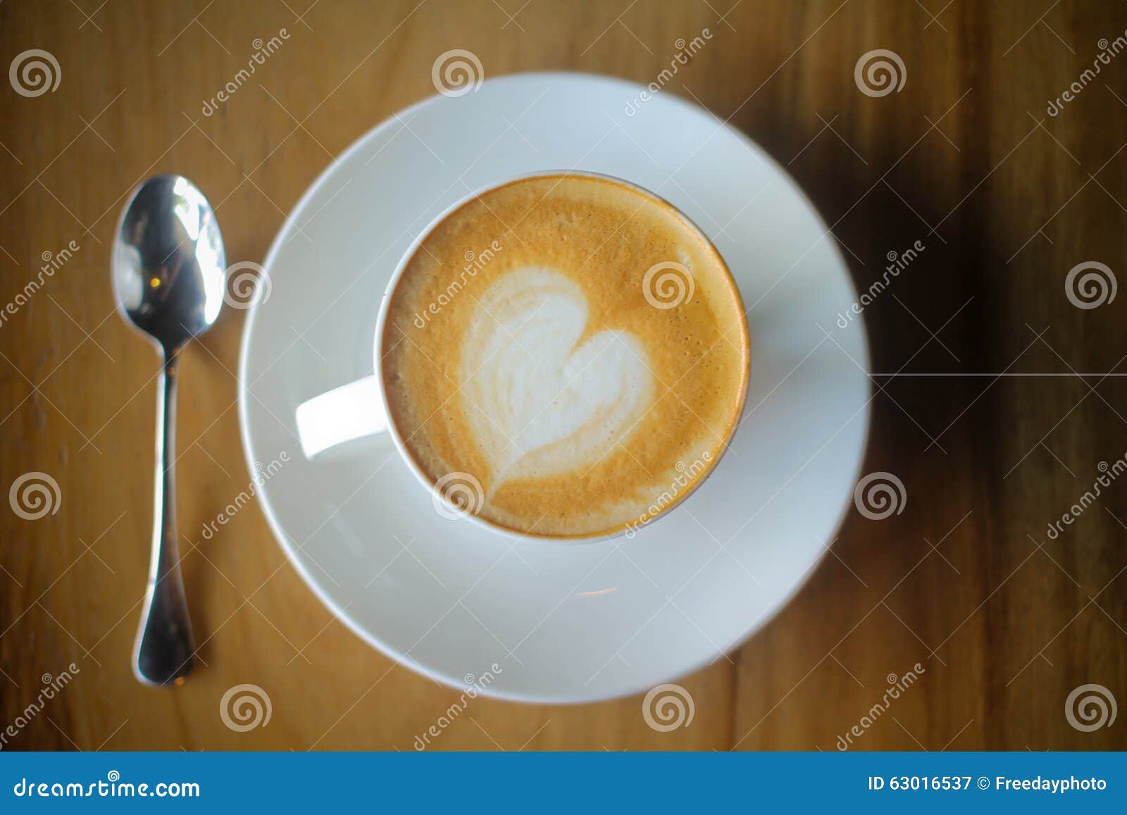 latte art on a cappucinno , on wooden table