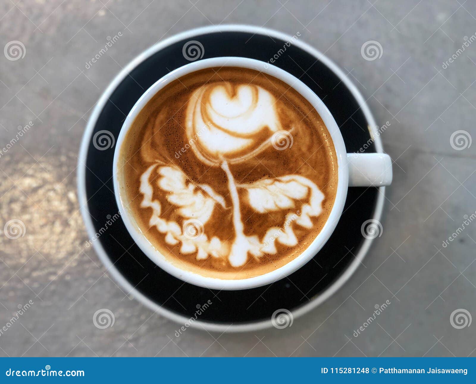 Latte Art Coffee Flower Shape in Black and White Cup on the Cement