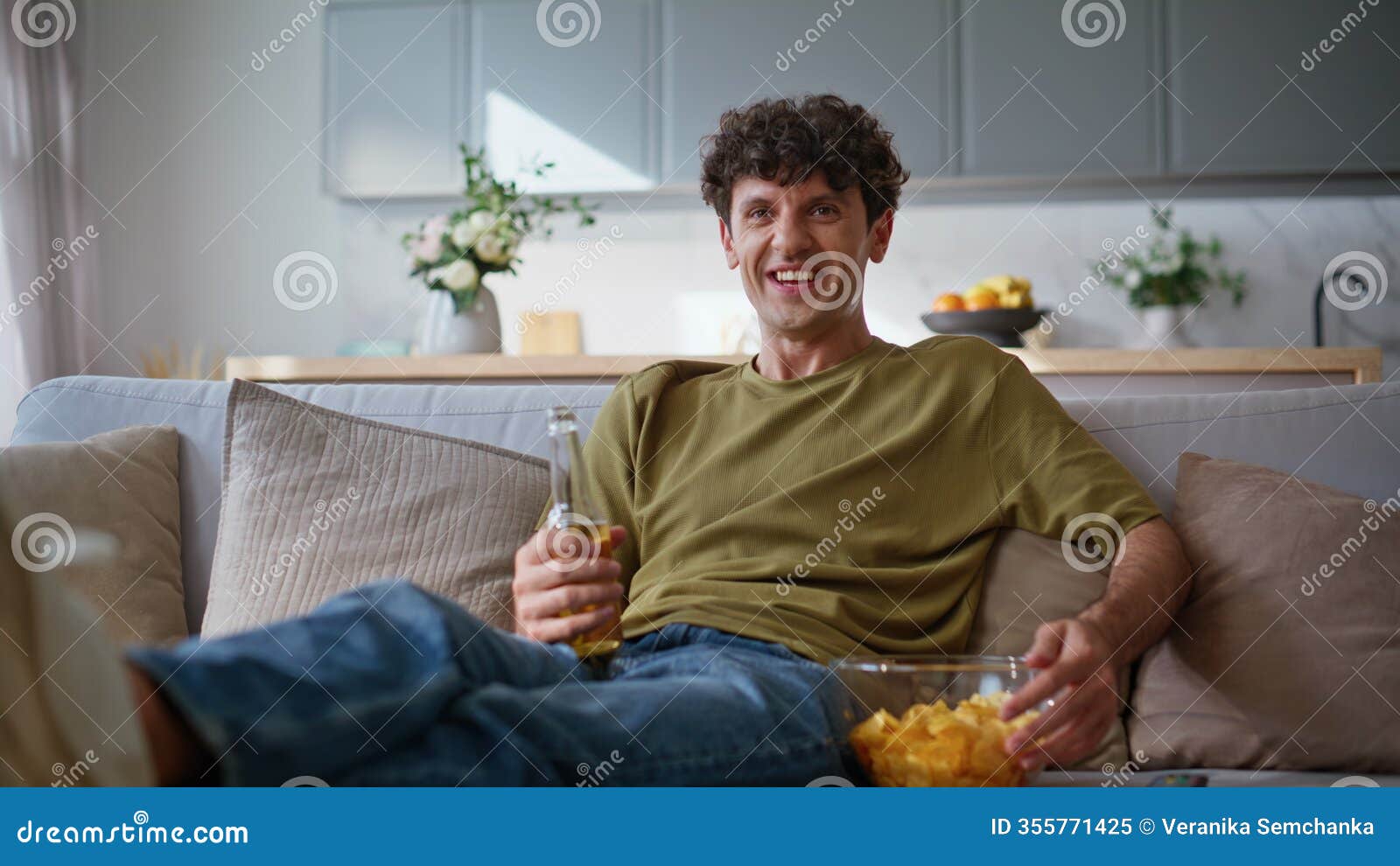 laughing man watching comedy on tv at home weekend zoom on. guy drinking beer